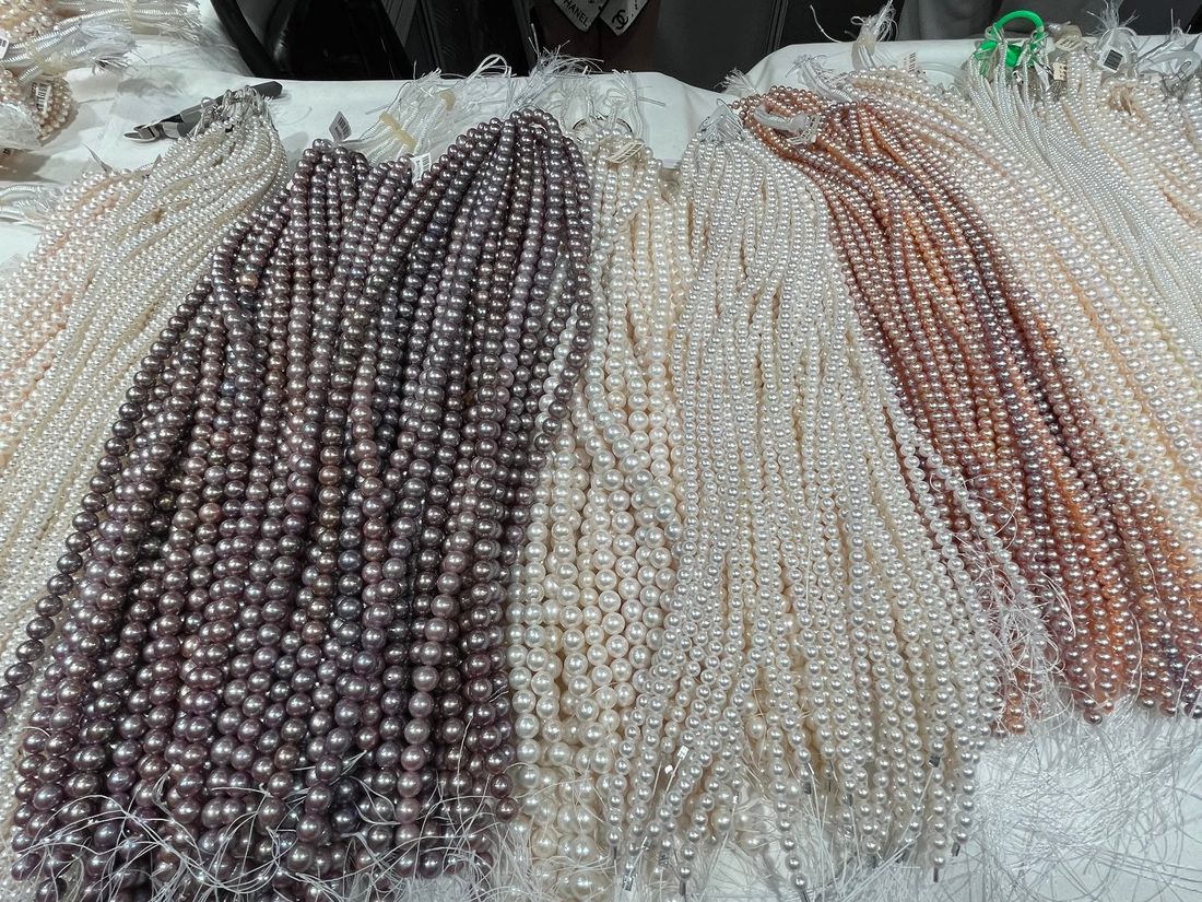 Freshwater pearl strands in white, cream, pastel and deeper tones on a sorting table